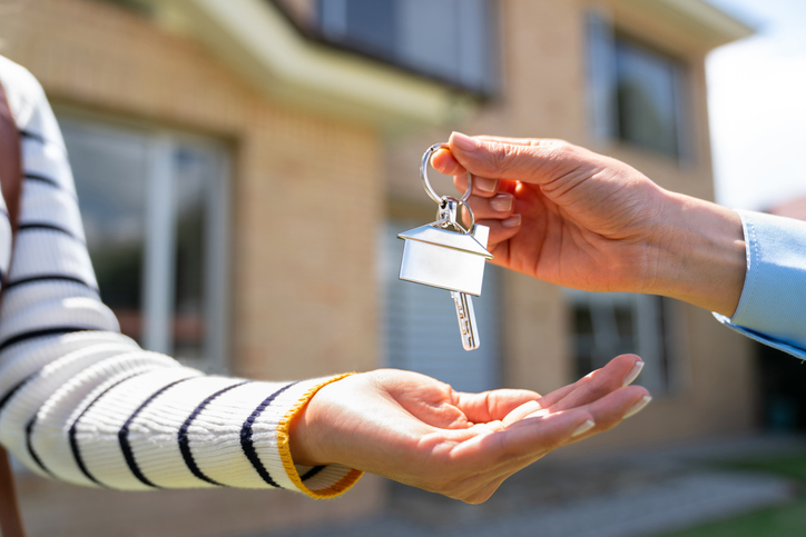 Close-up on a real estate agent giving the keys of their house to a new homeowner